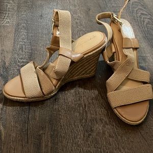 Tan strappy sandal with wedge heel.